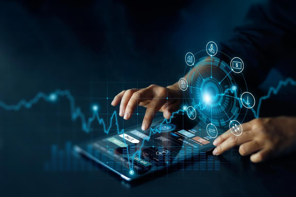 Hands typing on a tablet with glowing holographic data dashboard and circular analytics icons surrounding a central blue core.